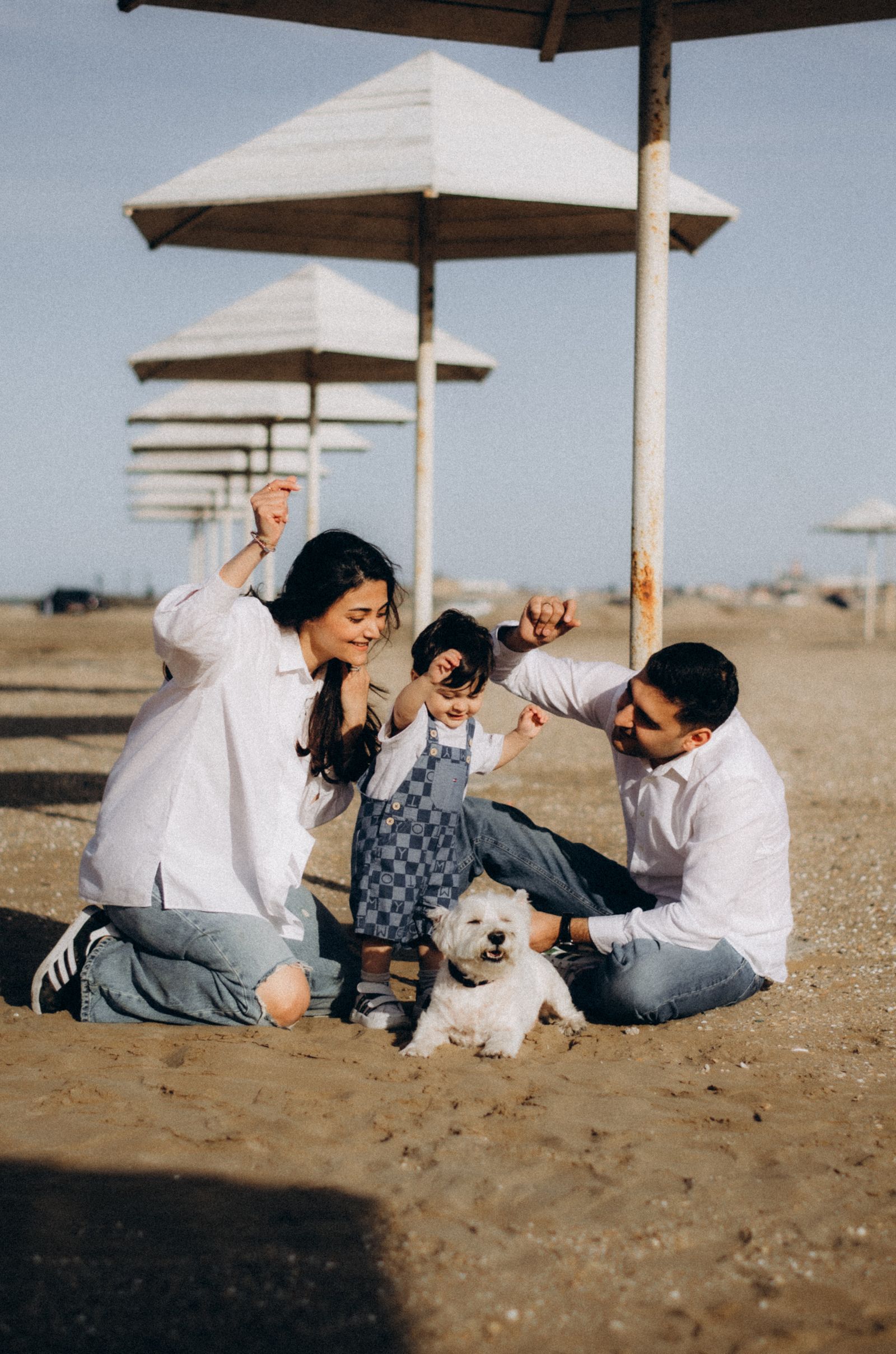 Familia jugando en la playa con su perro